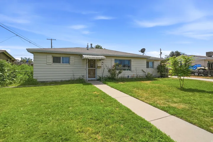 Single-story residence with a front lawn and a concrete walkway