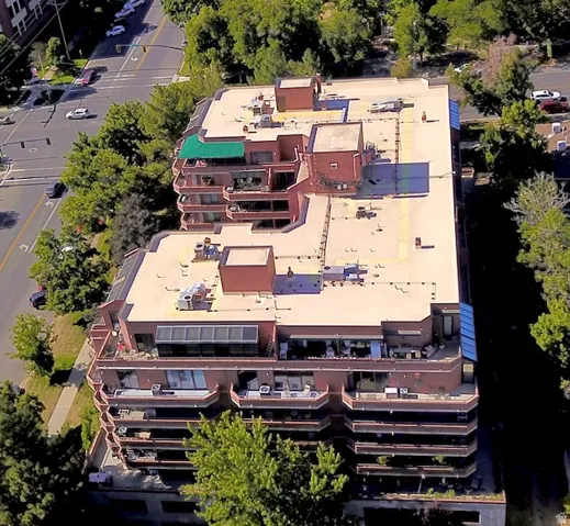 Multi-story building featuring extensive private balconies, a flat roofline, and brick-clad exterior