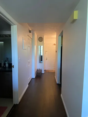 Dark wood-finish flooring throughout the hallway