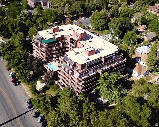Multi-story building featuring extensive private balconies, a central outdoor swimming pool, and a structured parking area