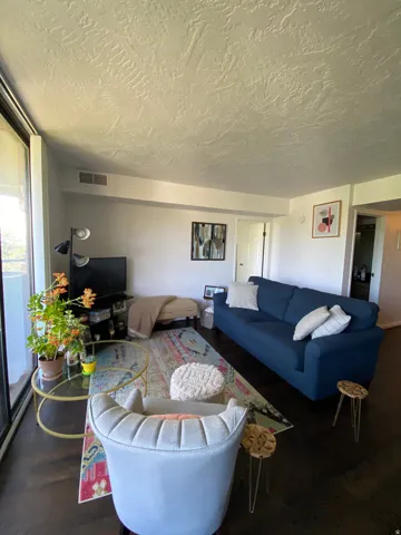 Dark wood-finish flooring, full-height windows, recessed lighting, and a white interior door