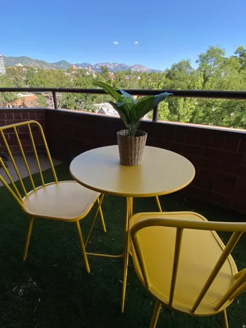 Balcony with a mountain backdrop, a dark metal railing, and a brick exterior wall