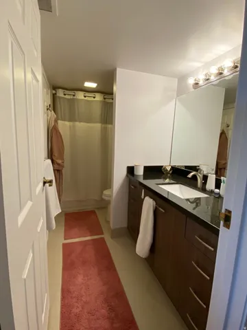 Extended single vanity with a dark countertop and undermount sink