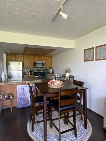 Kitchen featuring wood-finish cabinetry, stainless steel appliances, and a mosaic tile backsplash