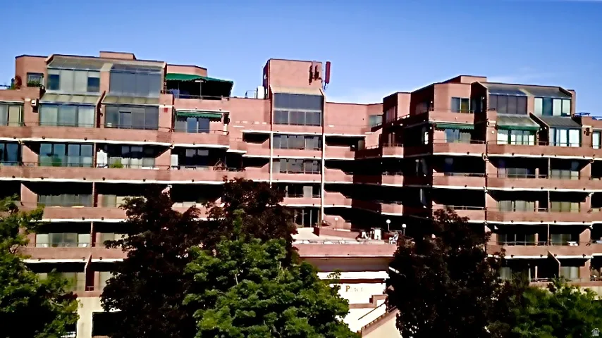 Brick exterior building with multiple balconies, large windows, and integrated sunrooms