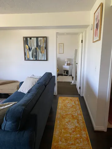 Dark wood-finish flooring extending into an open doorway with white trim