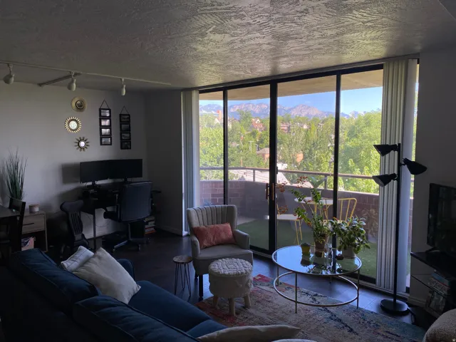 Sliding glass doors opening to a private balcony with mountain and tree scenery