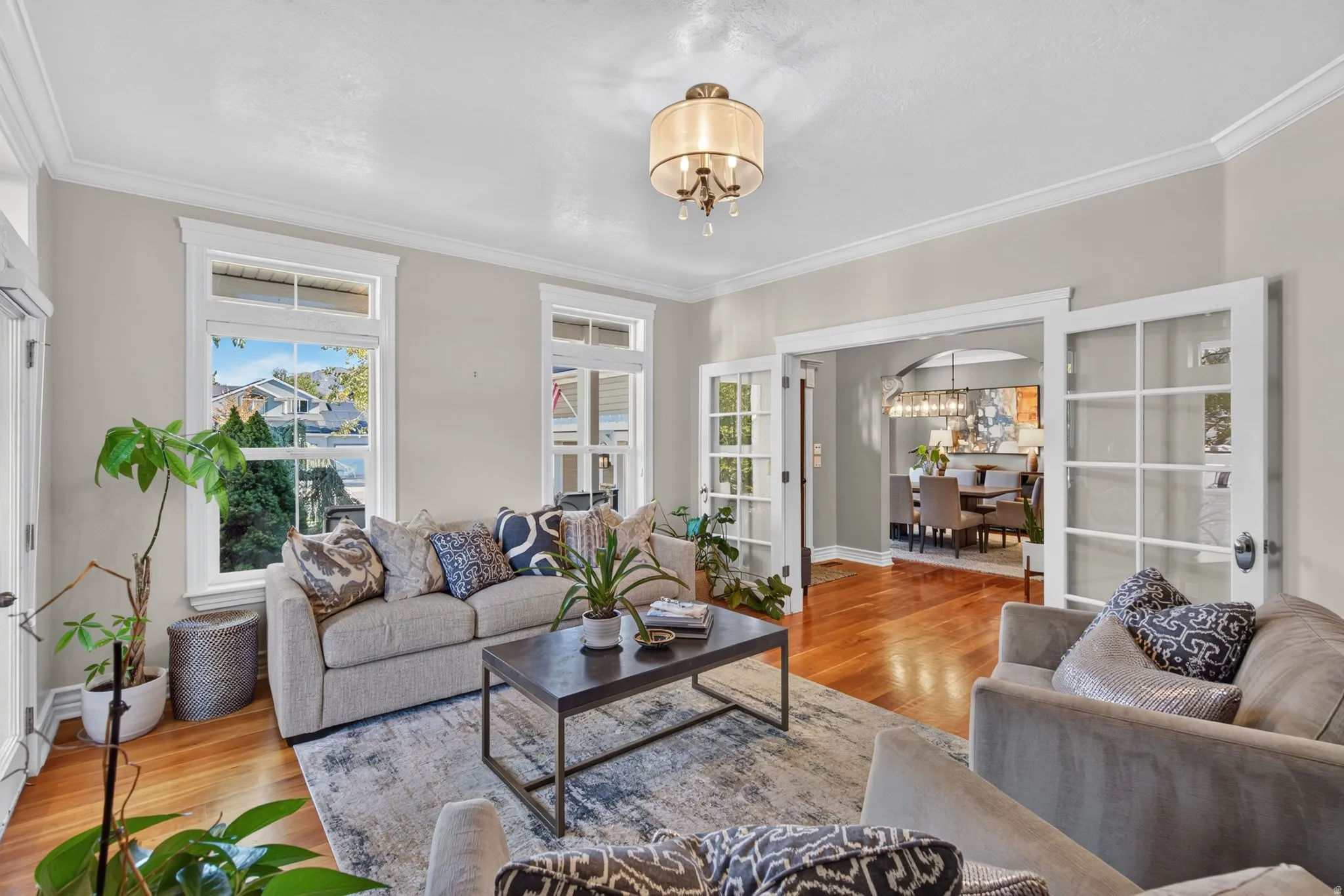 Hardwood flooring, crown molding, French doors, recessed lighting, and a decorative chandelier