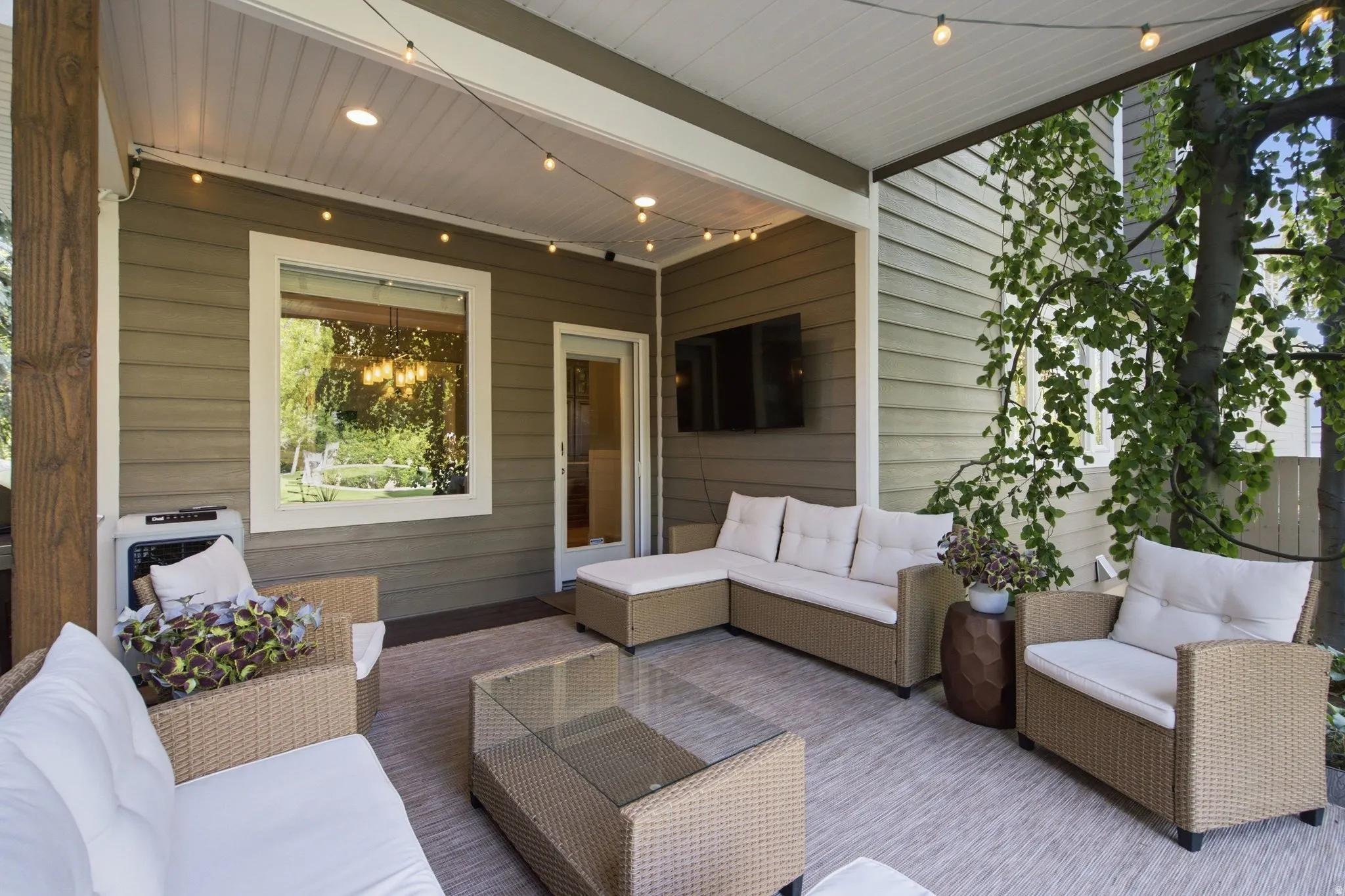 Covered patio featuring a wood-finish support beam, horizontal siding, and a white framed window