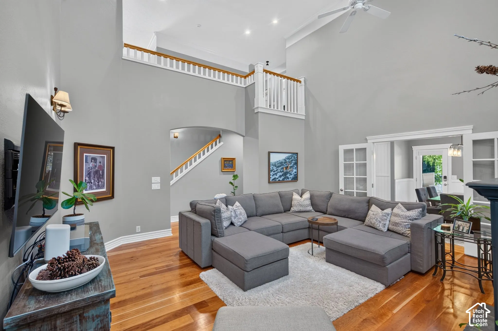 Vaulted ceilings, wood-finish flooring, white trim details, and an arched entry