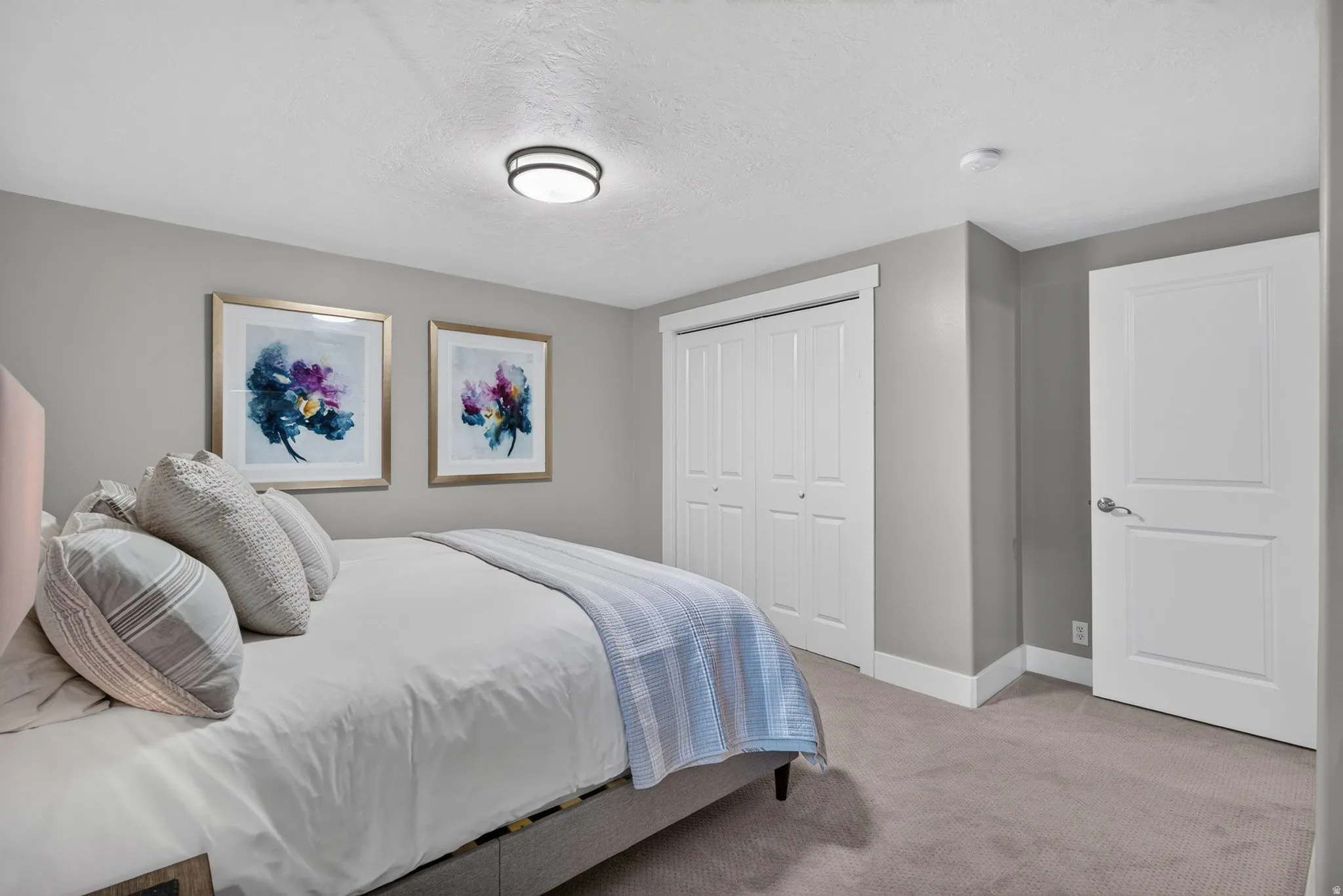 Neutral gray wall paint, recessed ceiling light, white paneled doors, carpeted flooring, and a flush mount ceiling light