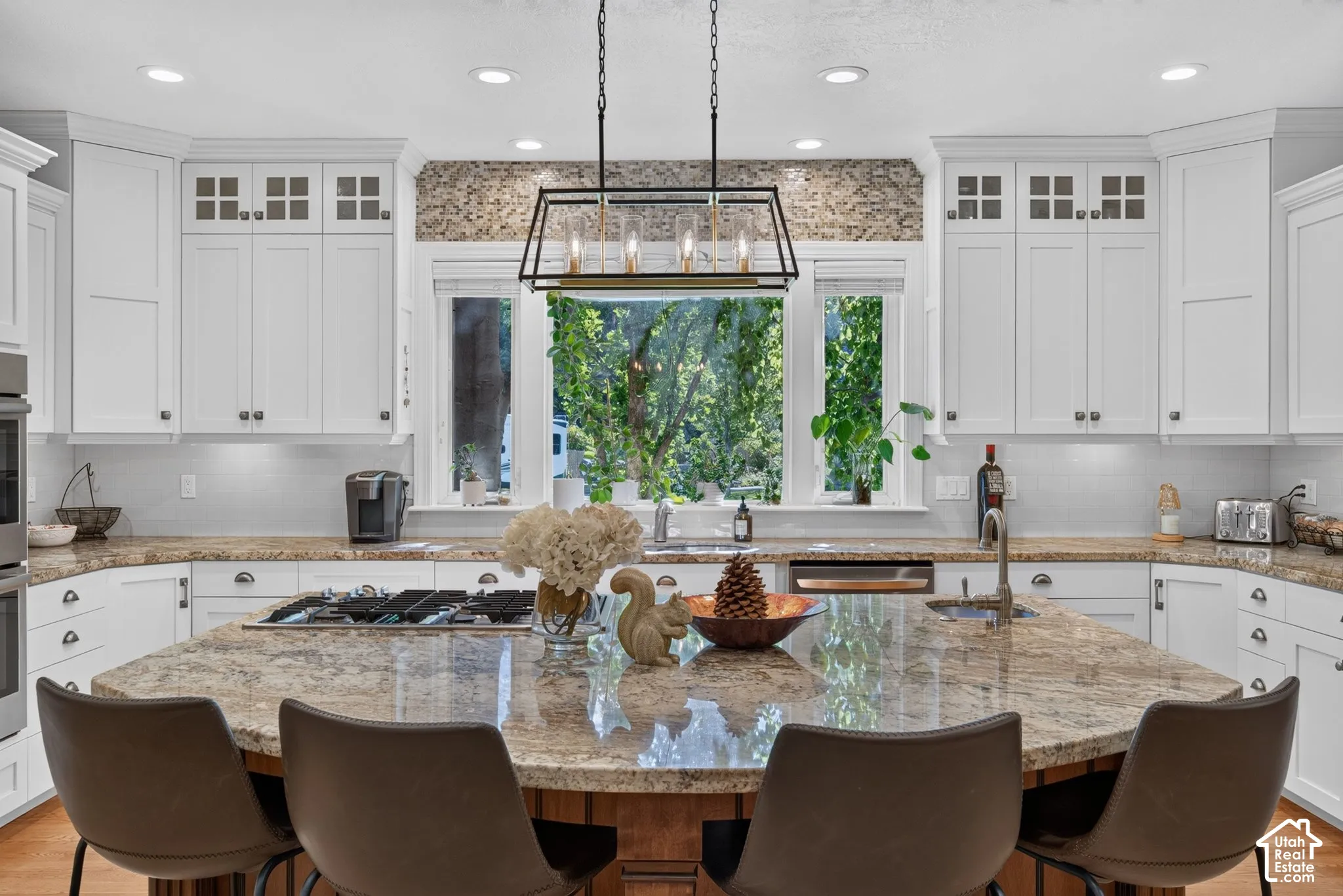 Expansive kitchen island with a stone countertop, built-in gas cooktop, and seating