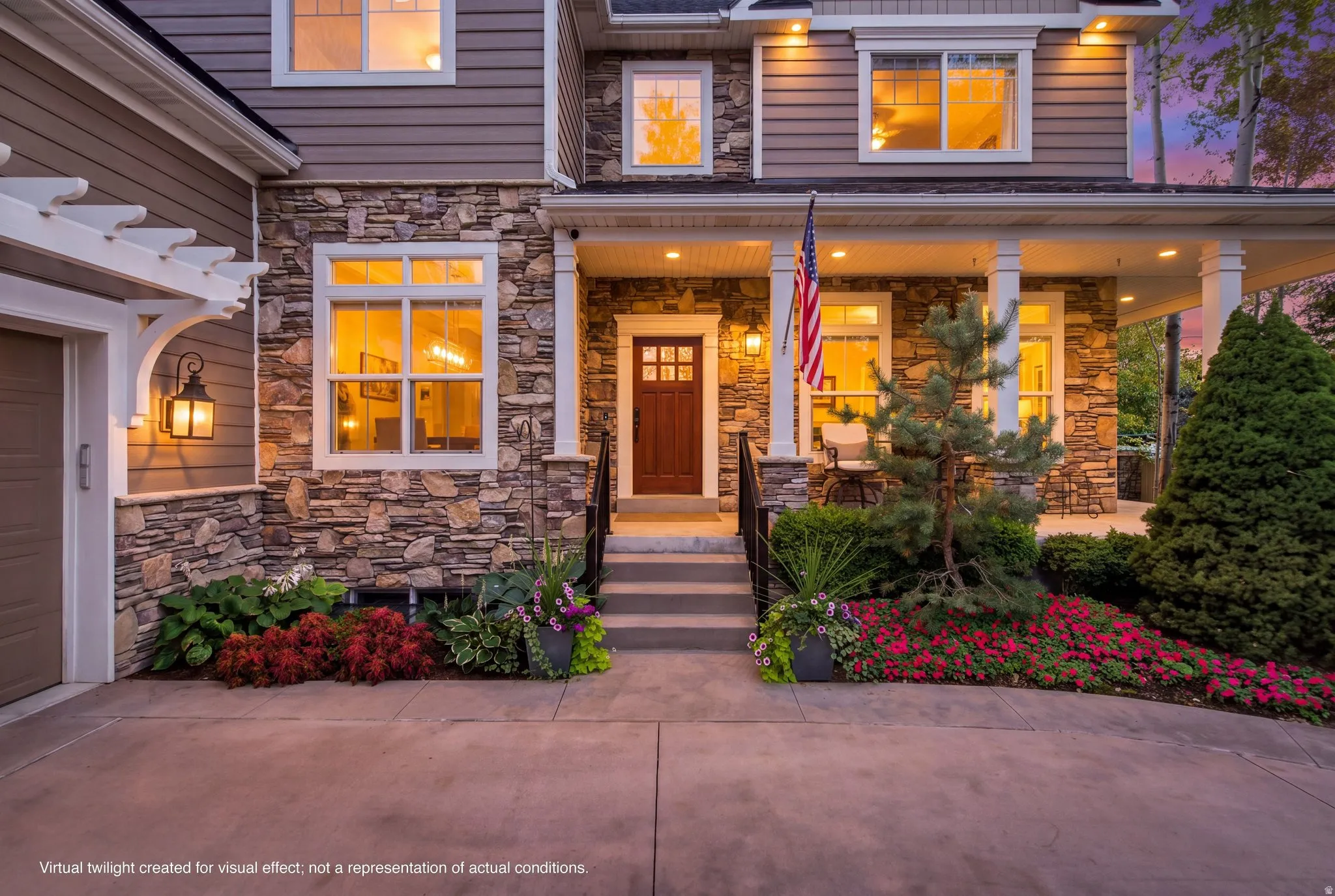Stone veneer exterior with horizontal siding, covered entry porch, white pergola element, decorative outdoor lanterns, and concrete driveway