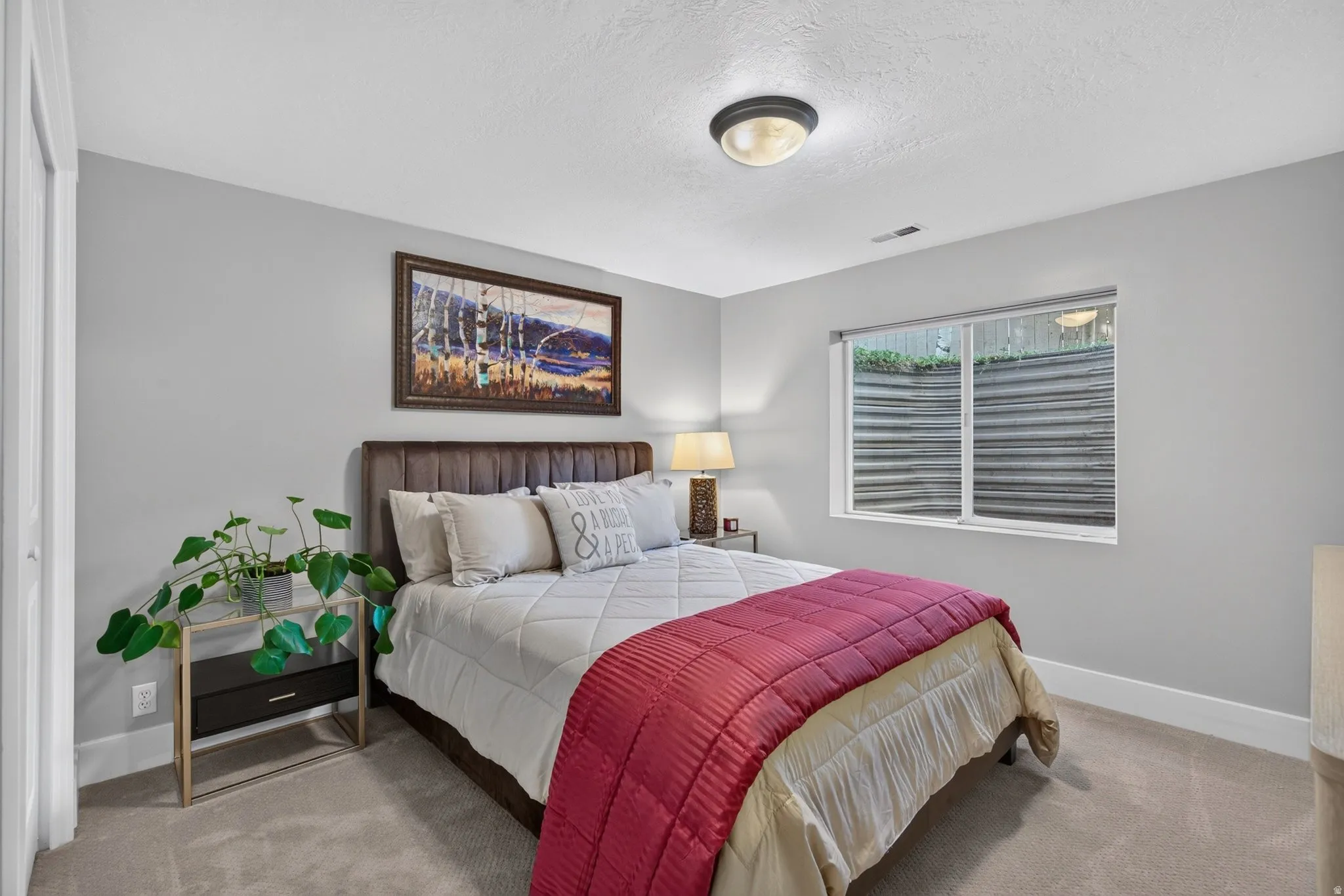 Light gray wall paint, white trim, recessed window, flush-mount ceiling light, and carpeted flooring