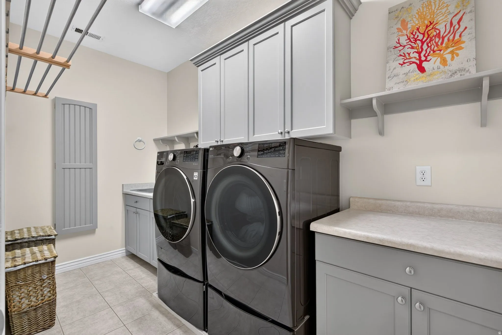 Laundry area with tile flooring, built-in cabinetry, and a countertop