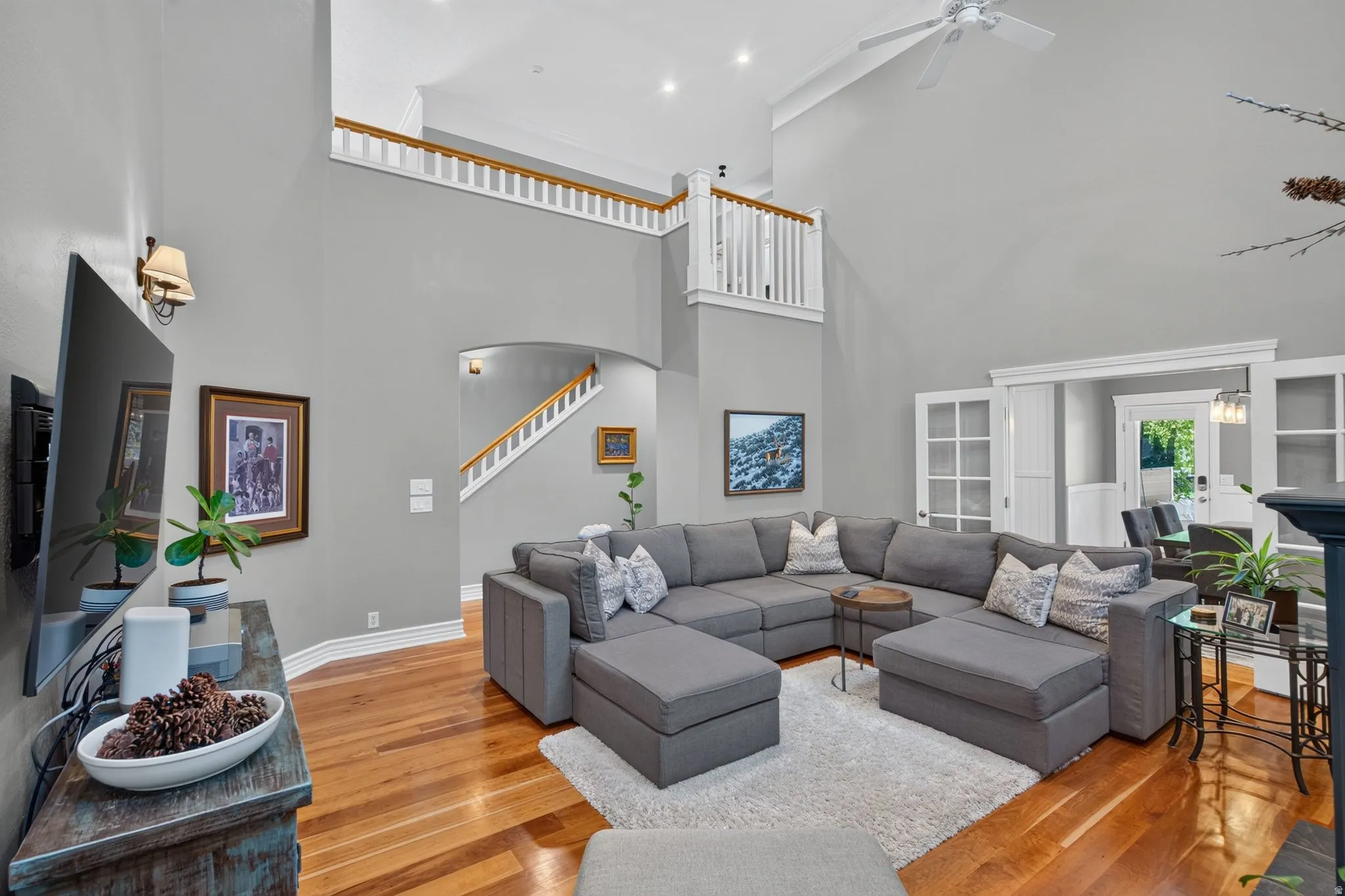 Vaulted ceilings, wood-finish flooring, white trim details, and an arched entry