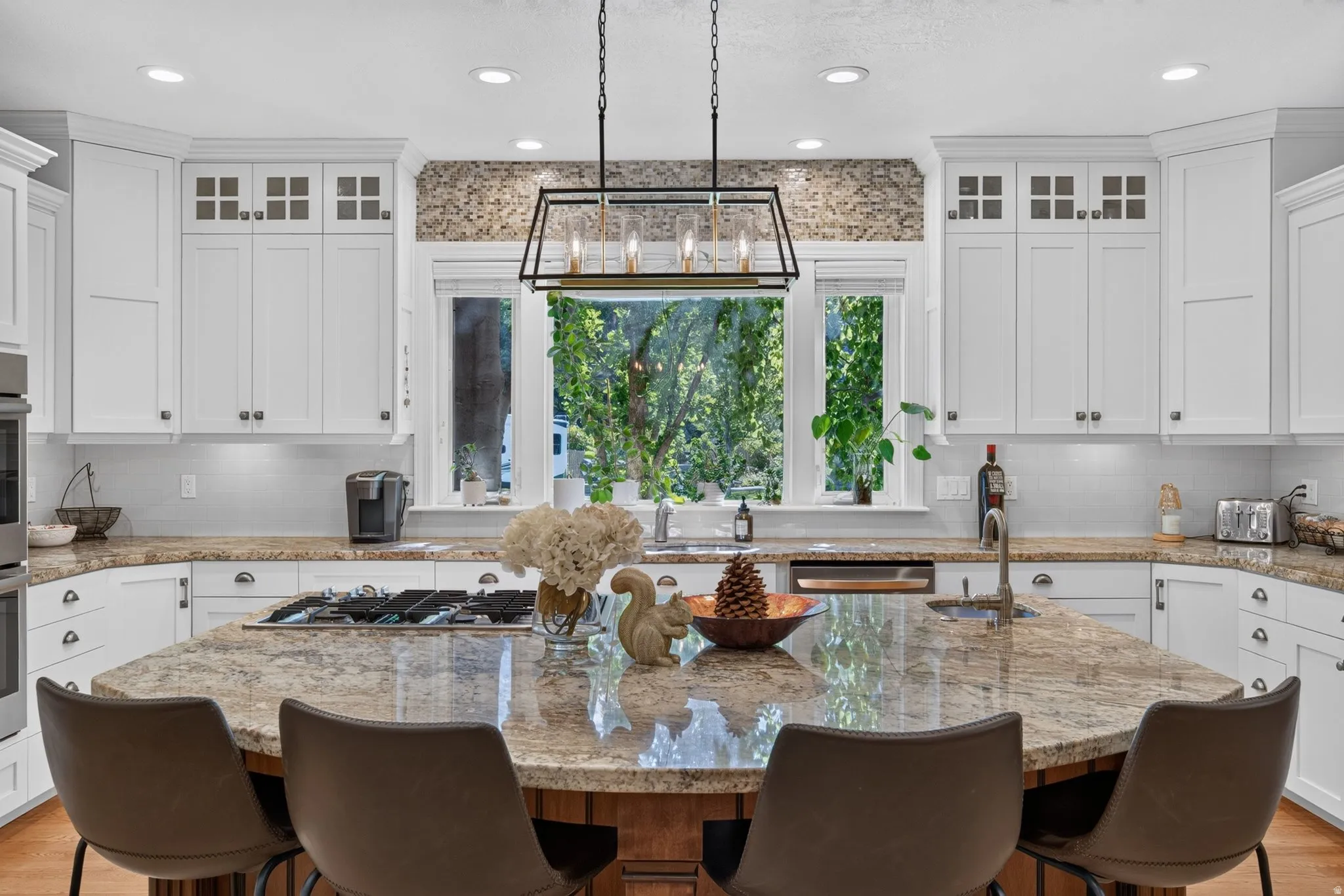 Expansive kitchen island with a stone countertop, built-in gas cooktop, and seating