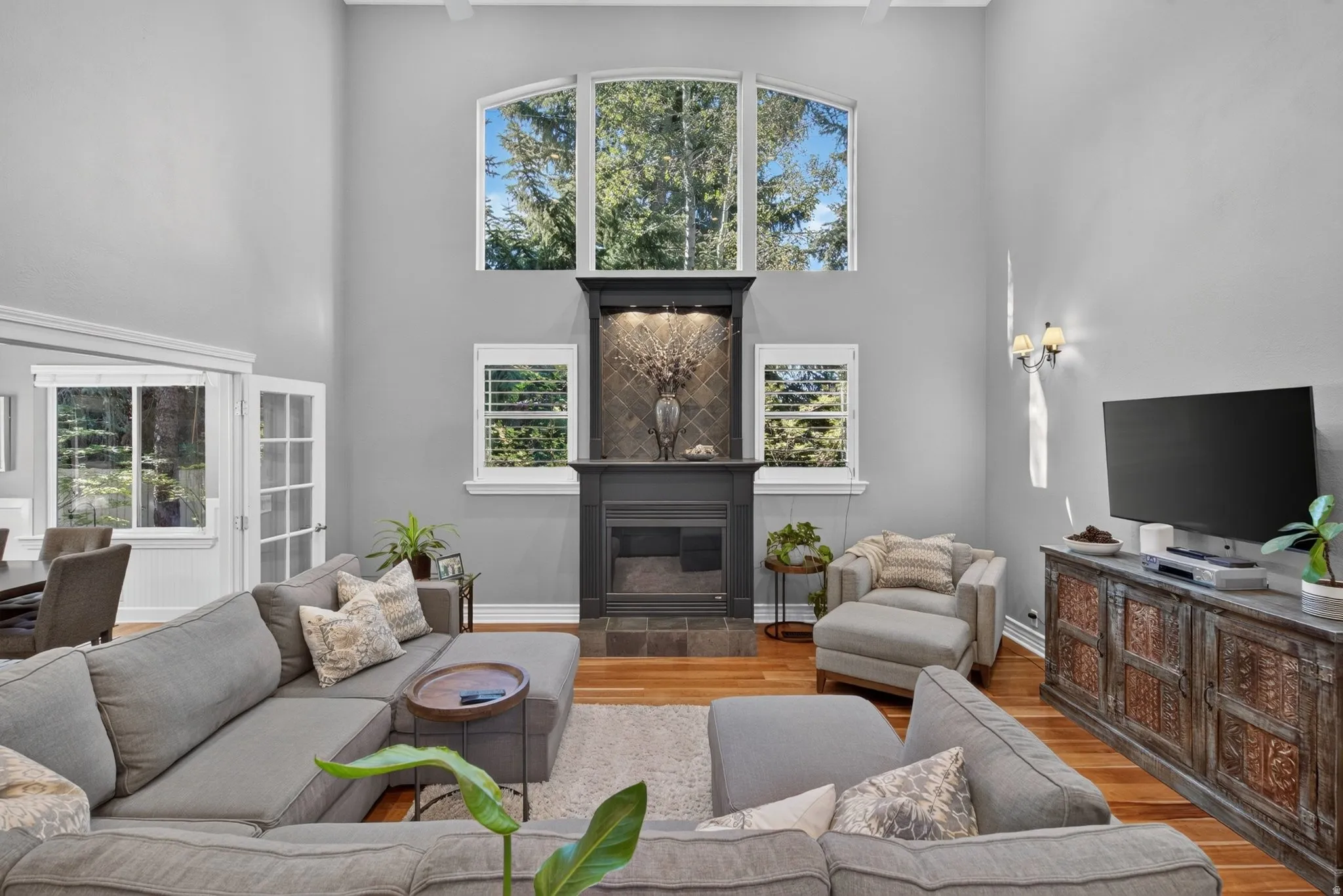 Vaulted ceilings, hardwood flooring, fireplace, built-in shelving, and large windows
