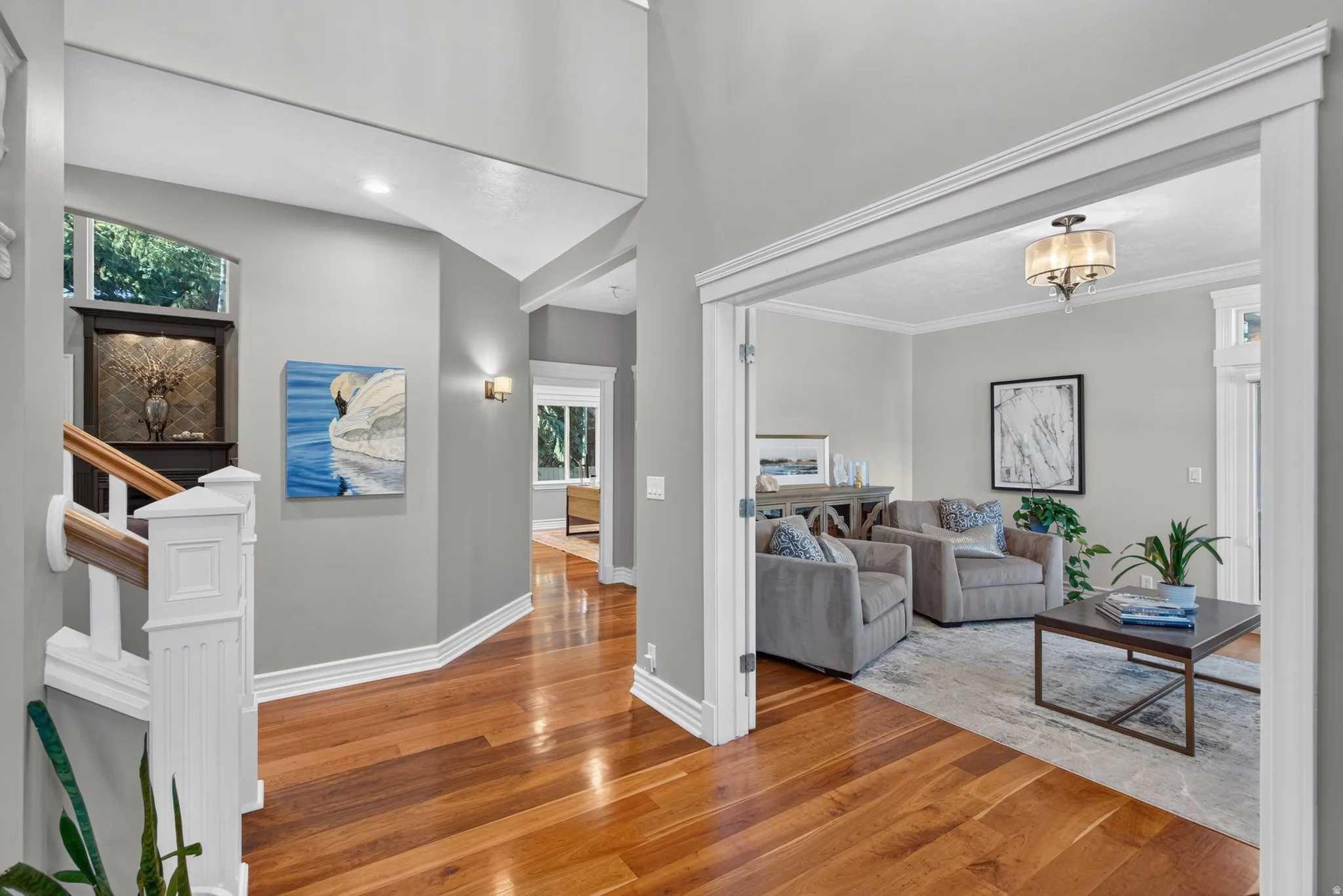 Elegant foyer featuring rich wood-finish flooring, soaring ceilings with recessed lighting, and neutral wall finishes