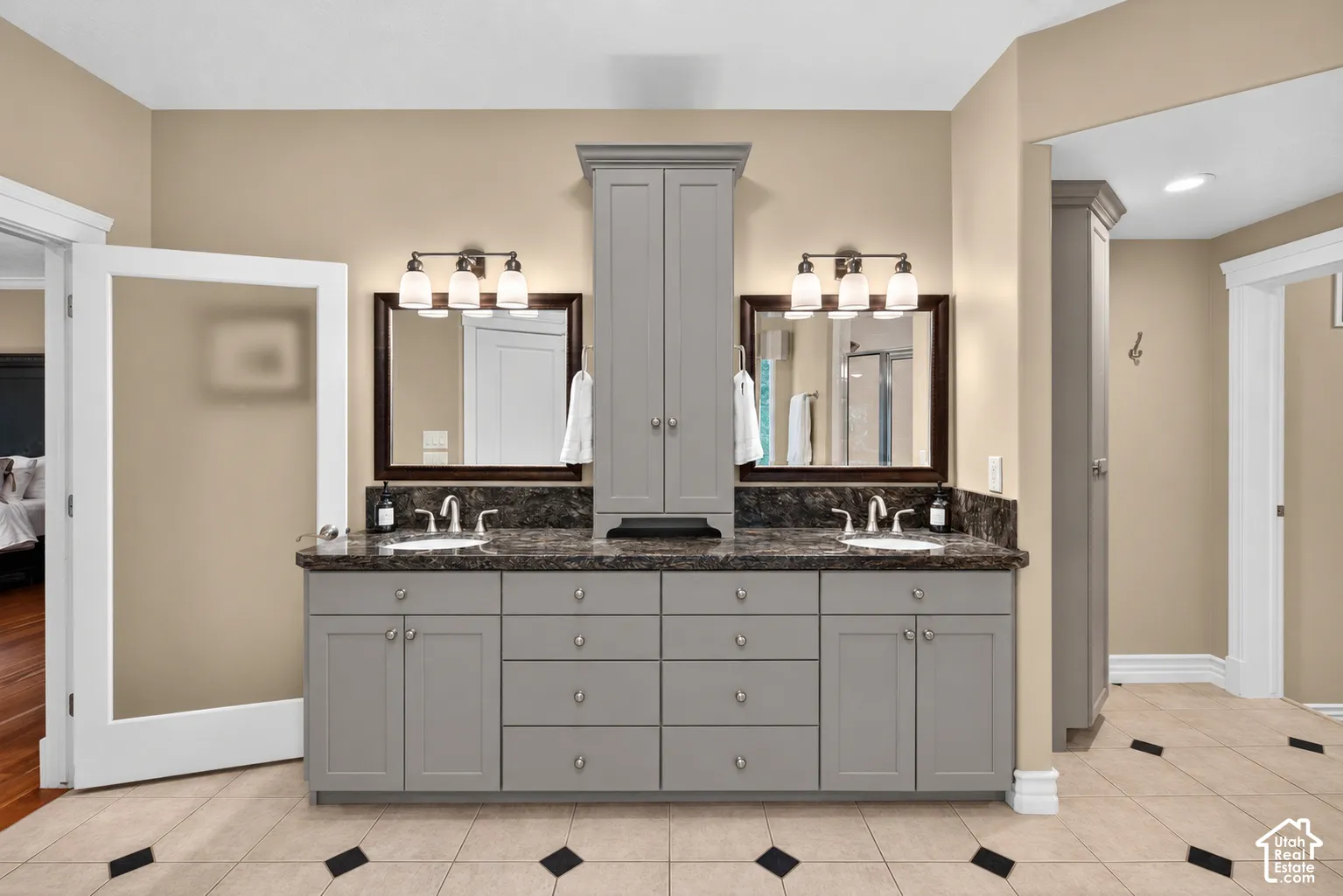 Dual vanity with undermount sinks and dark stone countertops