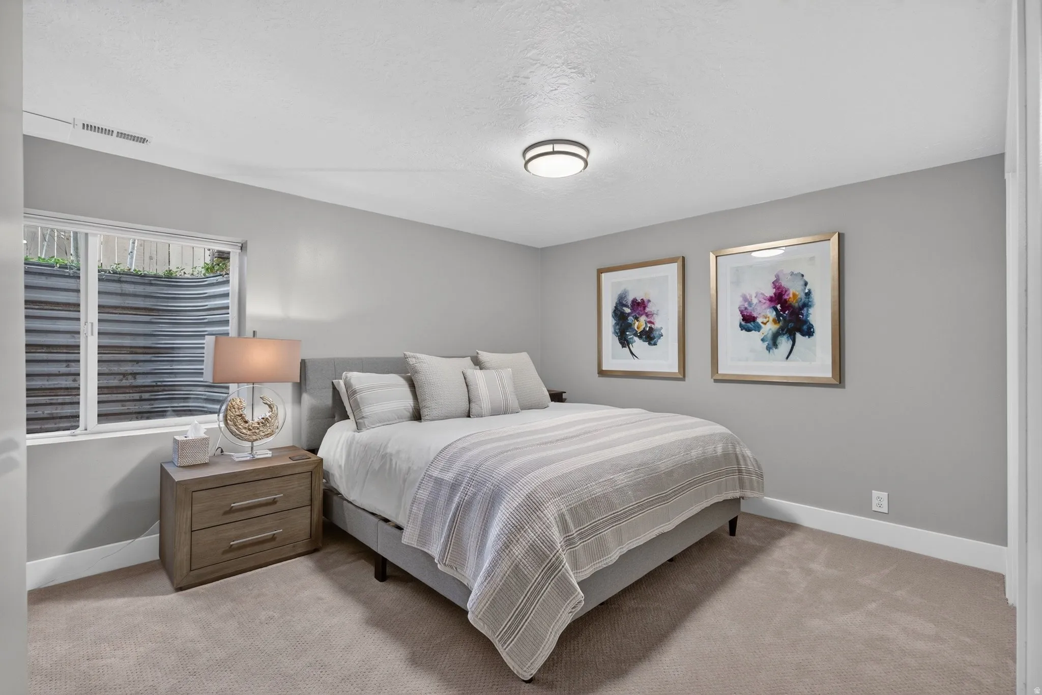 Recessed window, ceiling-mounted light fixture, light gray wall paint, light-colored carpeting, white trim