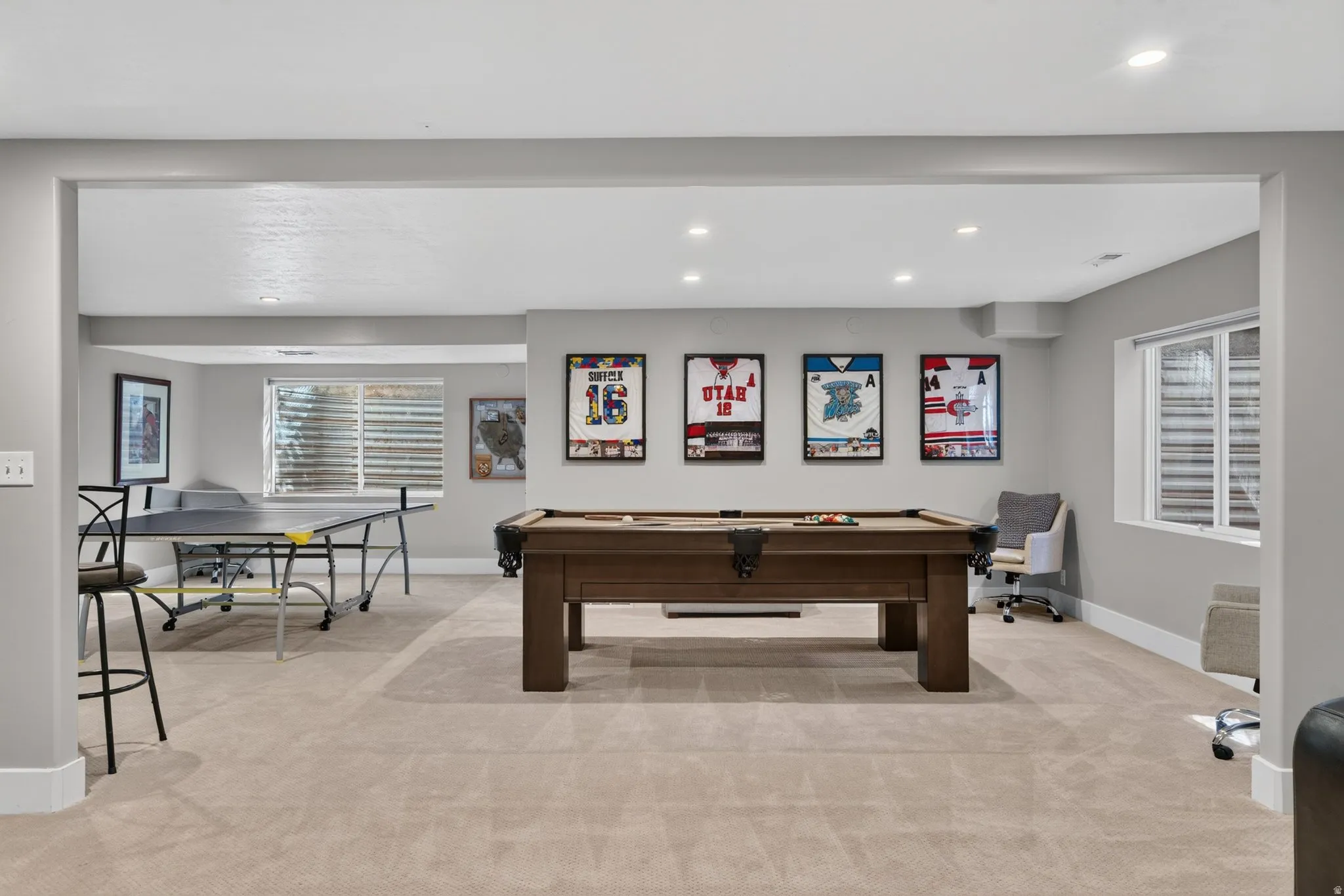 Recessed ceiling lighting, light neutral-toned carpeting, and a window with blinds