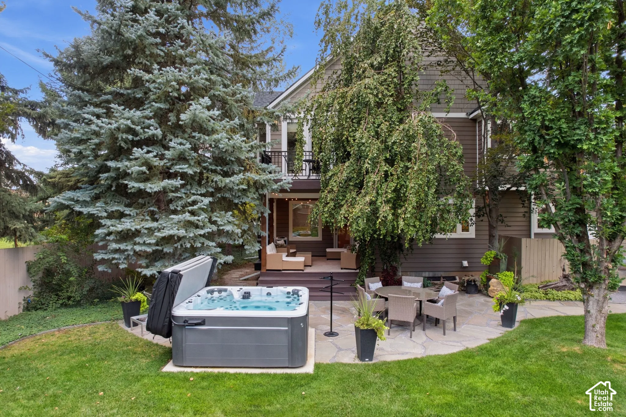 Expansive backyard featuring a hot tub, flagstone patio, and mature trees