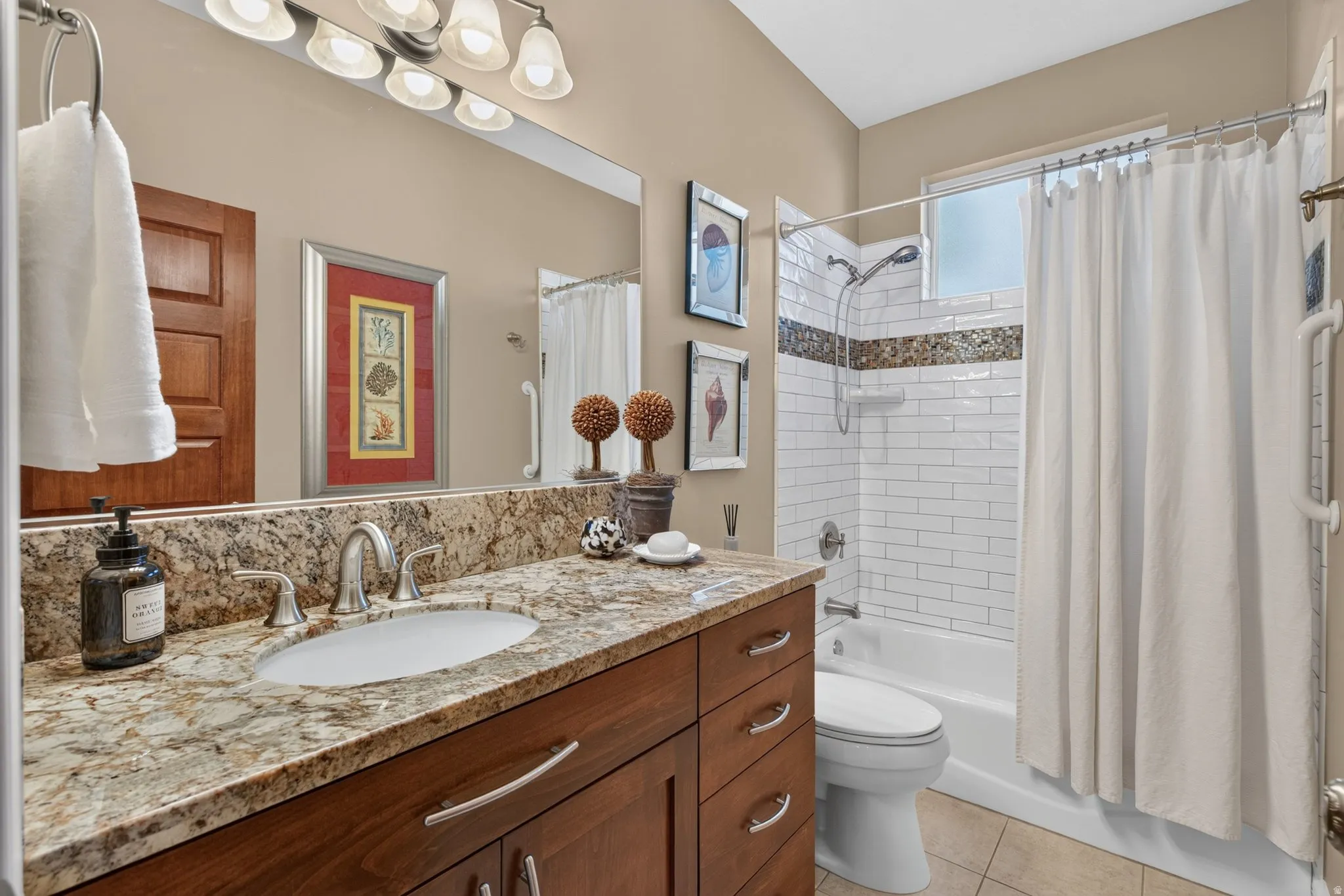 Spa-inspired bathroom featuring a granite-topped double vanity with wood cabinetry, polished nickel fixtures, and recessed lighting