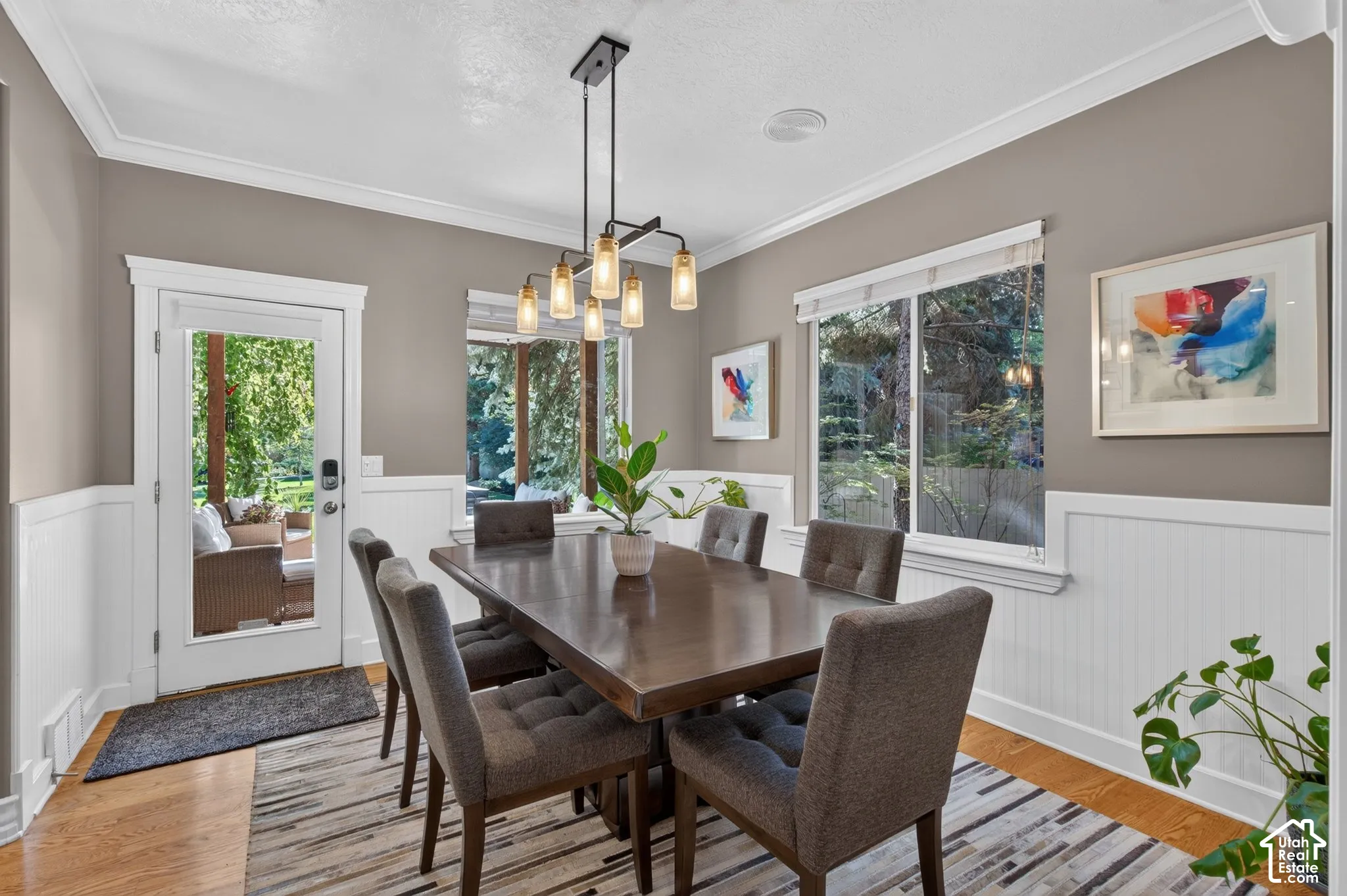 Hardwood flooring complemented by white wainscoting and a crisp crown molding detail