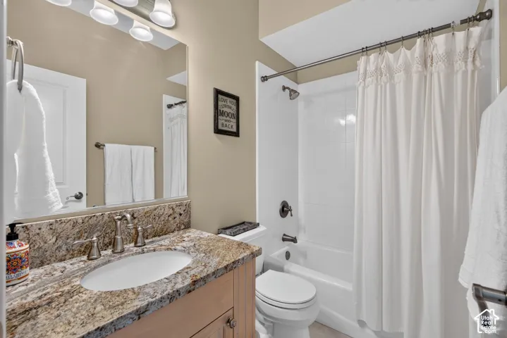 Vanity with a polished stone countertop, undermount sink, and brushed nickel faucet
