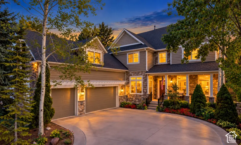 Multi-story residence featuring stone and siding exterior, a three-car garage, pergola detailing, and a covered entryway