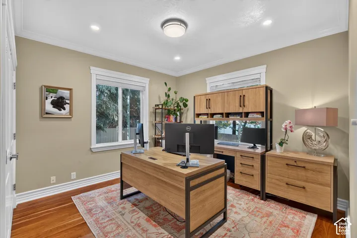 Recessed lighting, crown molding, wood-finish flooring, and white trim throughout