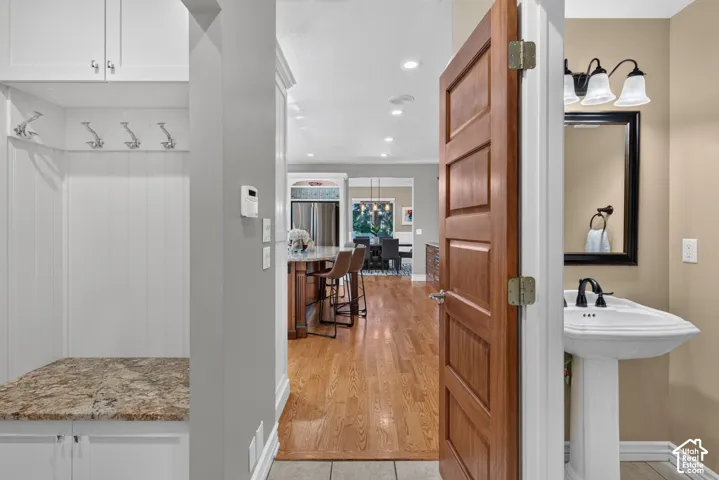 Built-in mudroom bench with granite-style countertop, white cabinetry, and wall-mounted hooks