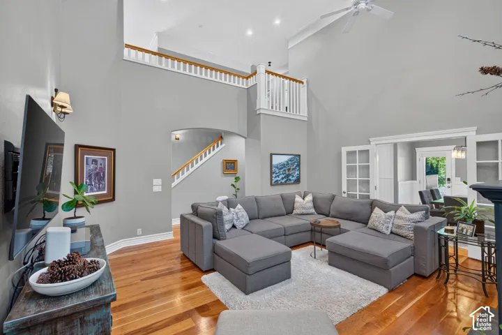 Vaulted ceilings, wood-finish flooring, white trim details, and an arched entry