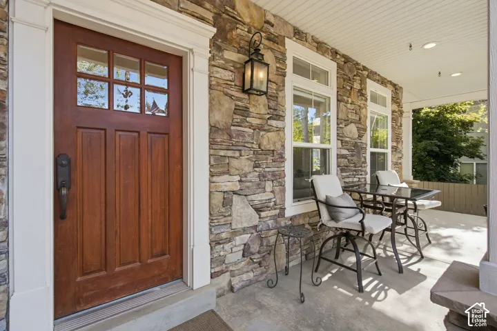 Stonework exterior with a wooden entry door featuring glass panes and white trim