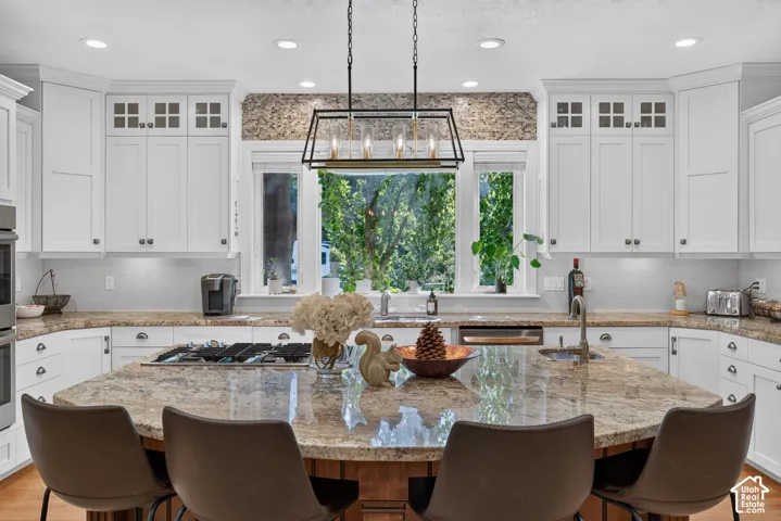Expansive kitchen island with a stone countertop, built-in gas cooktop, and seating