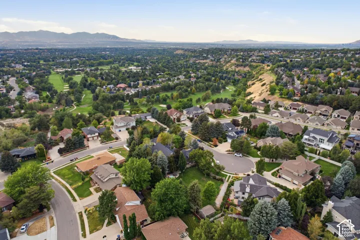Expansive community featuring mature trees, residential properties, and a golf course