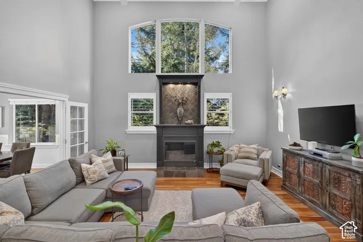 Vaulted ceilings, hardwood flooring, fireplace, built-in shelving, and large windows