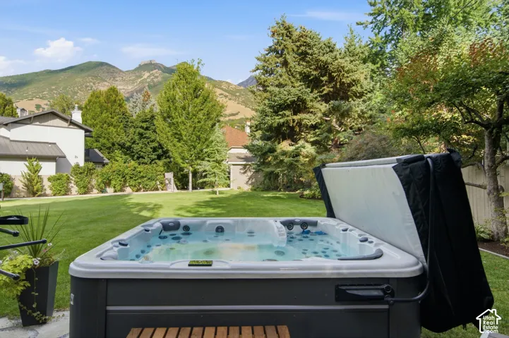 Expansive outdoor spa with a hinged cover, set on a paver patio