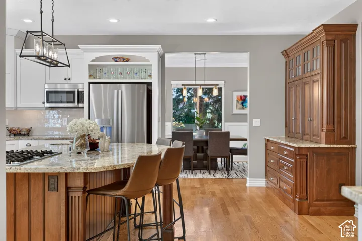 Gourmet kitchen with granite countertops, stainless steel appliances, and wood-finish flooring