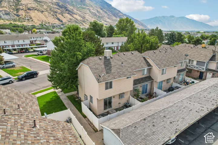 Two-story exterior with a pitched roofline, paved driveway, and private fenced yard