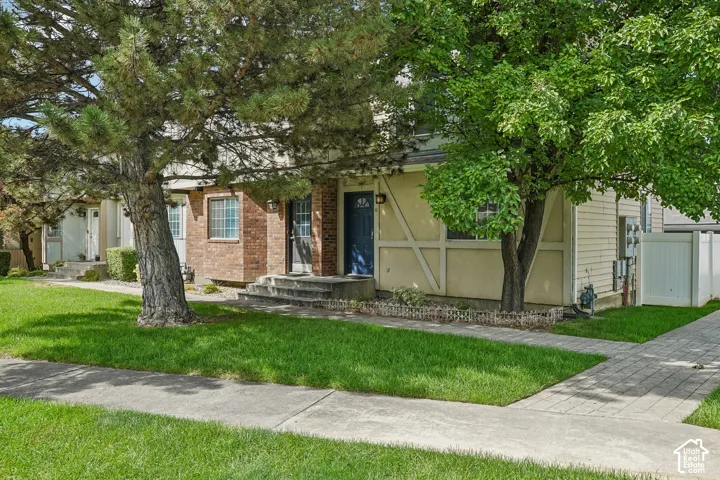 Brick-faced and horizontal siding exteriors with mature trees, established landscaping, and paved walkways