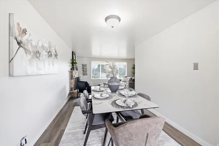 Modern dining space featuring wood-finish flooring, a contemporary ceiling light fixture, and light-toned walls