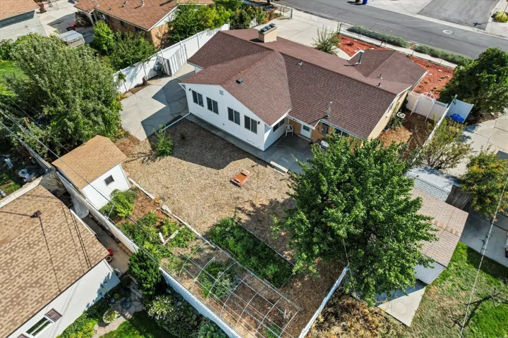 Expansive property featuring an updated shingle roof, white exterior siding, a detached shed, a zero scape yard, and mature trees
