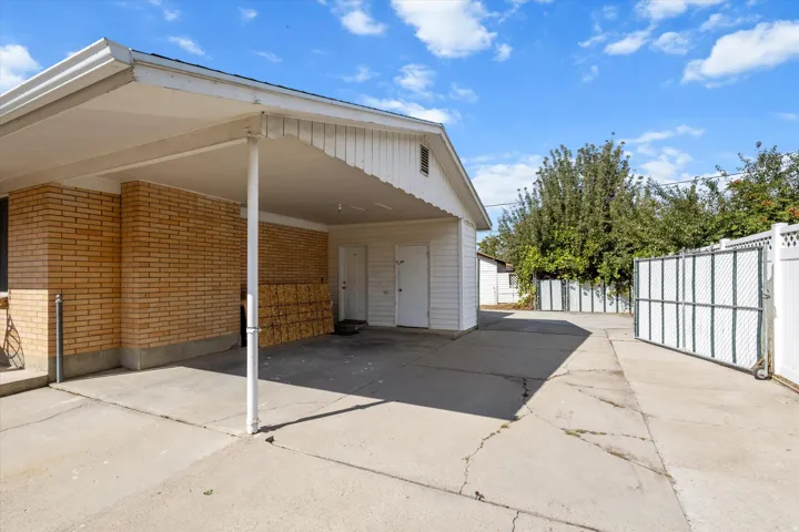 Covered carport with concrete apron and brick exterior featuring clean lines and modern proportions