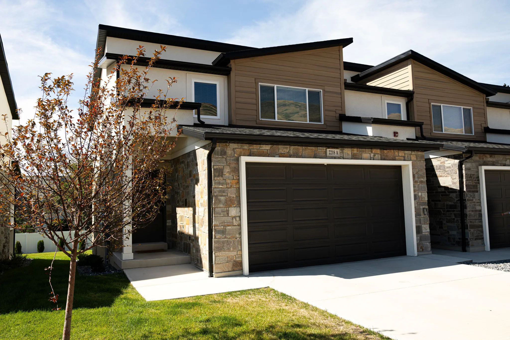 Contemporary exterior with a stone veneer facade and horizontal siding