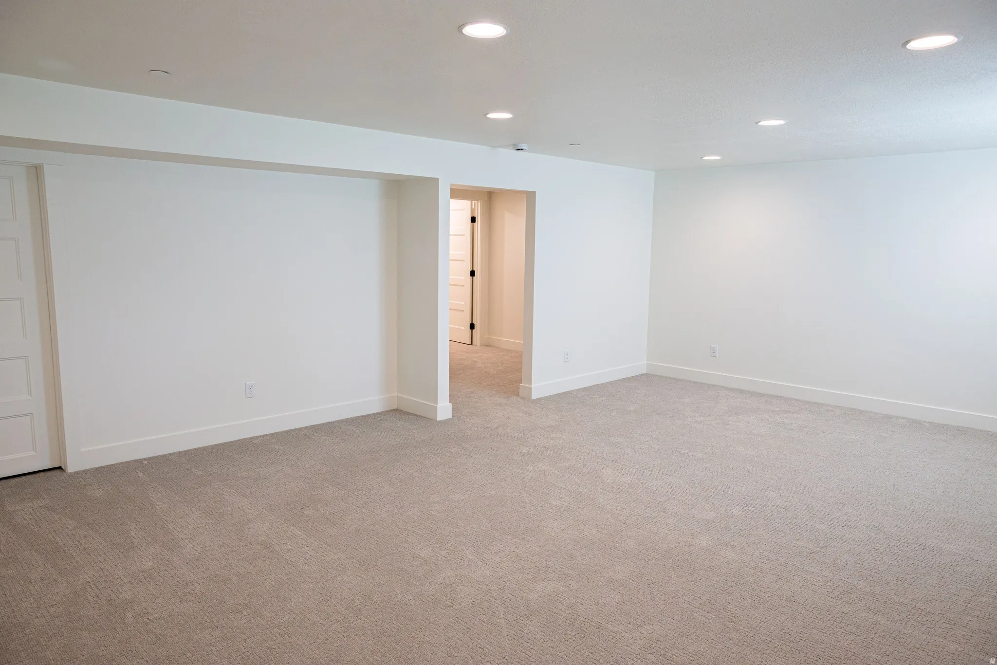 Spacious room with recessed lighting, light gray carpet, and white walls