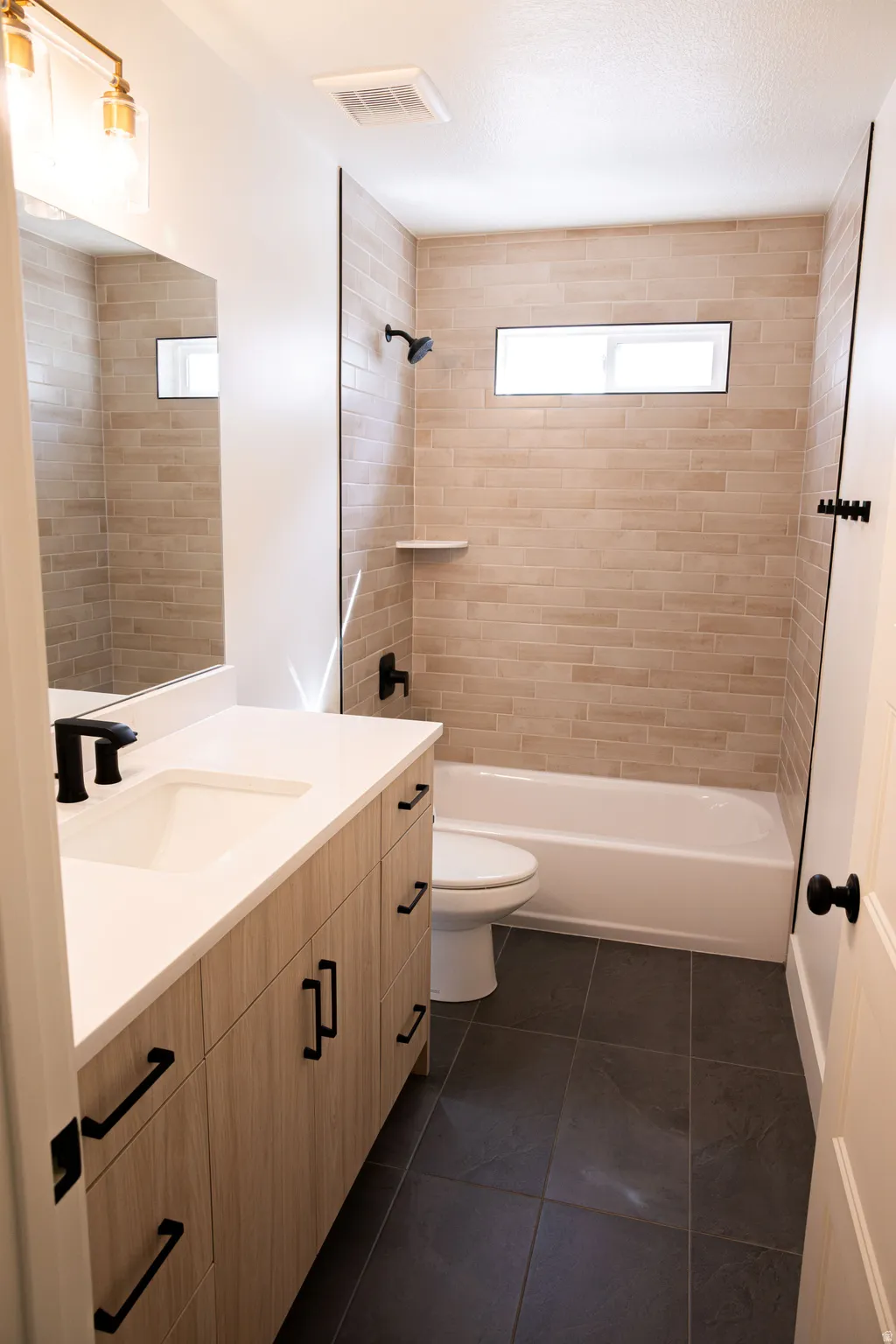 Vanity with wood-finish cabinetry and black hardware