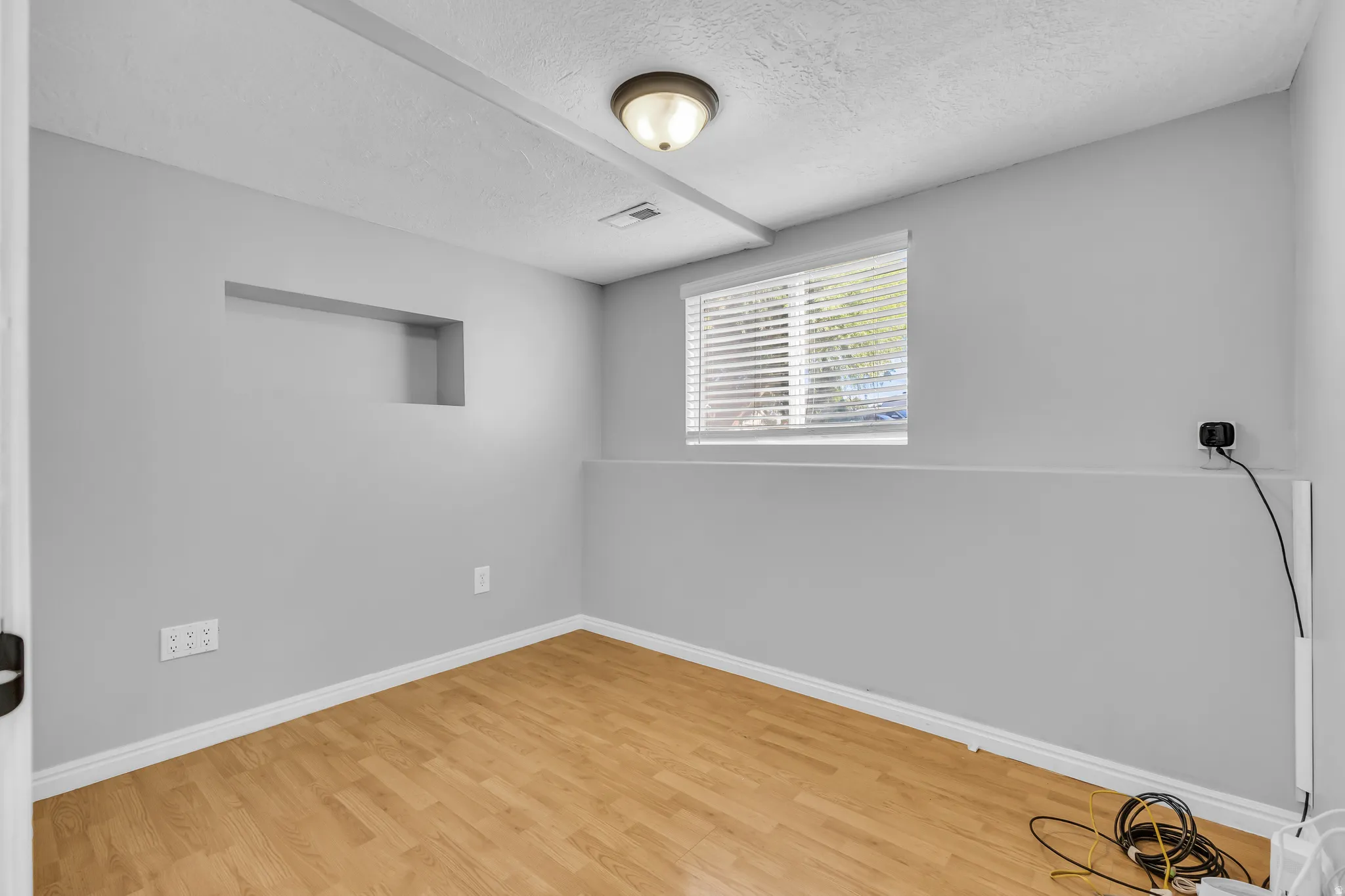Wood-finish flooring with white trim and a recessed wall niche