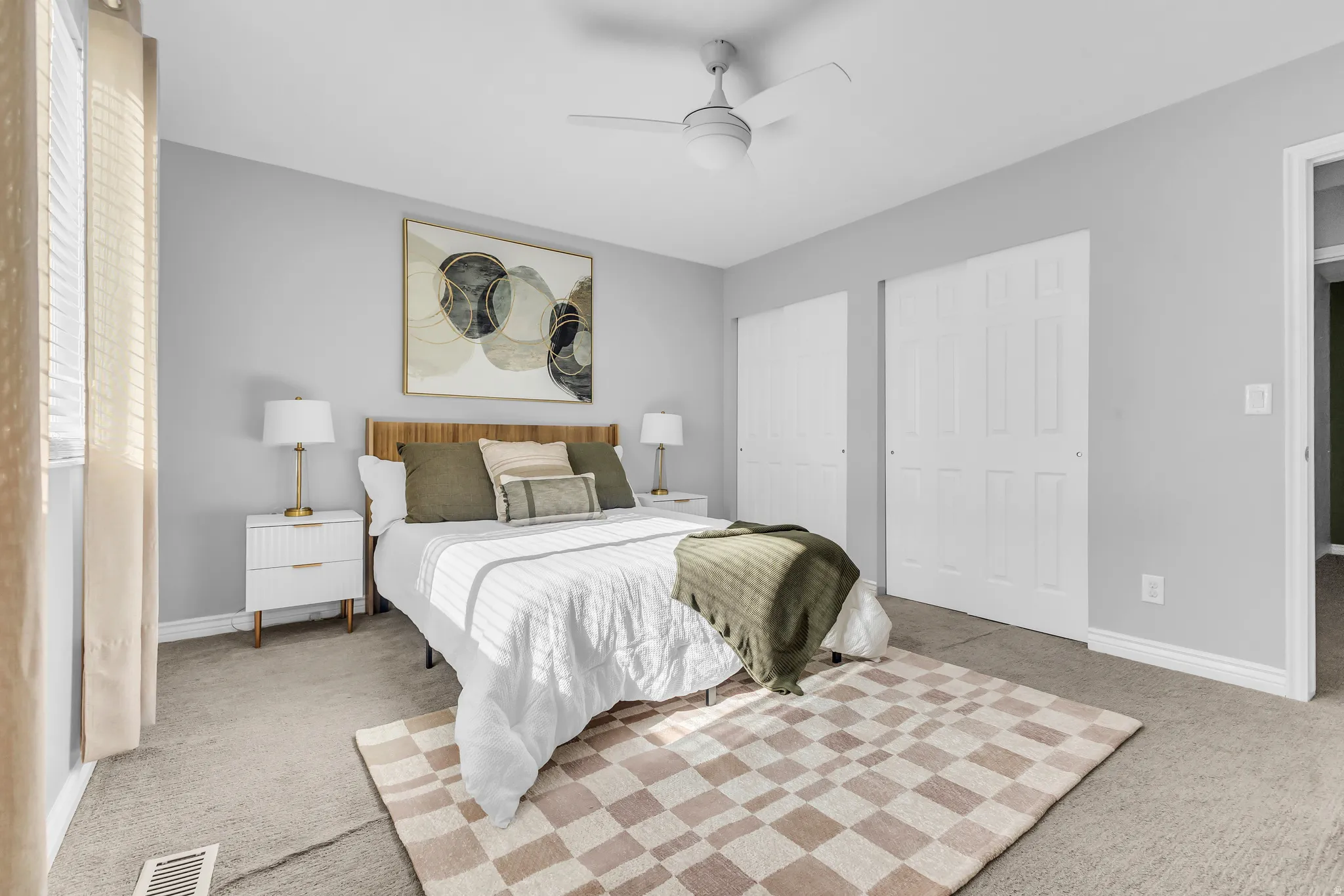 Neutral wall paint, carpet flooring, dual sliding closet doors, ceiling fan, and window blinds